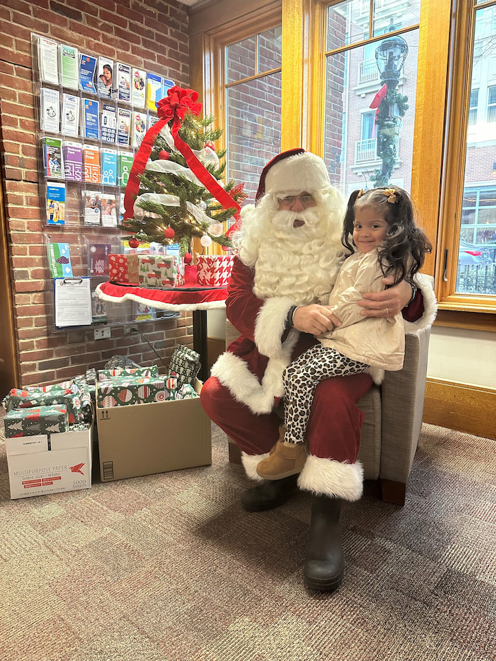 A girl sitting with Santa.