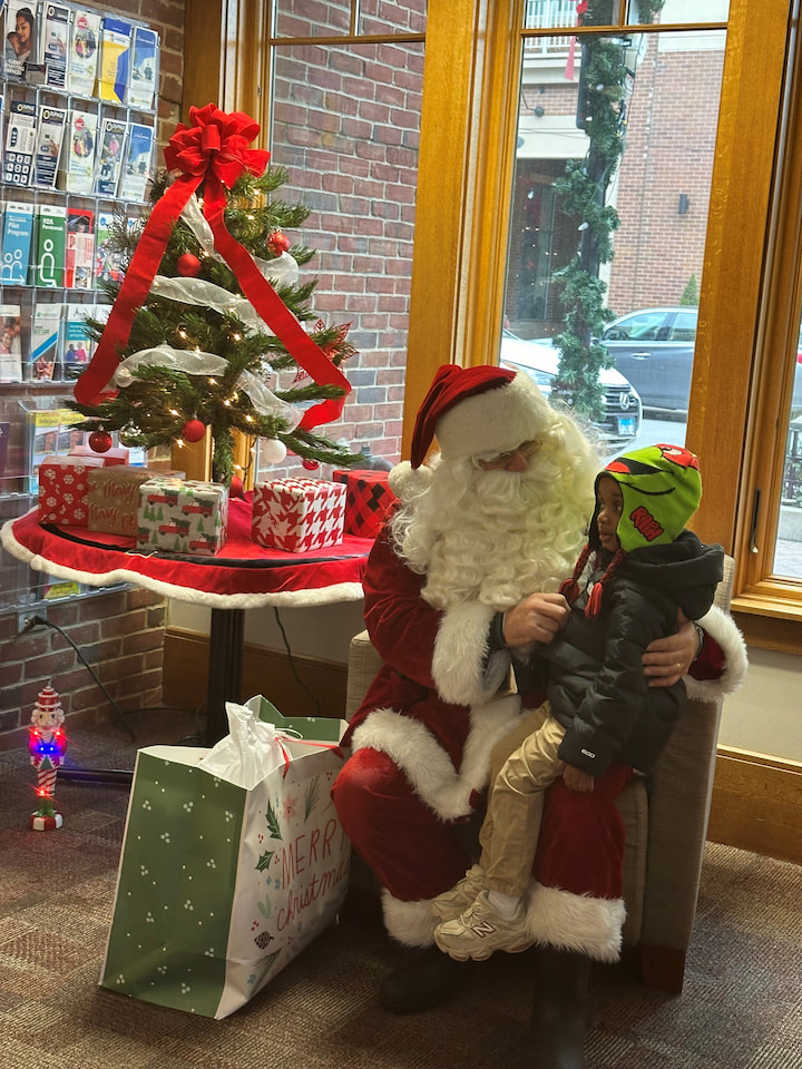 A boy sitting with Santa.