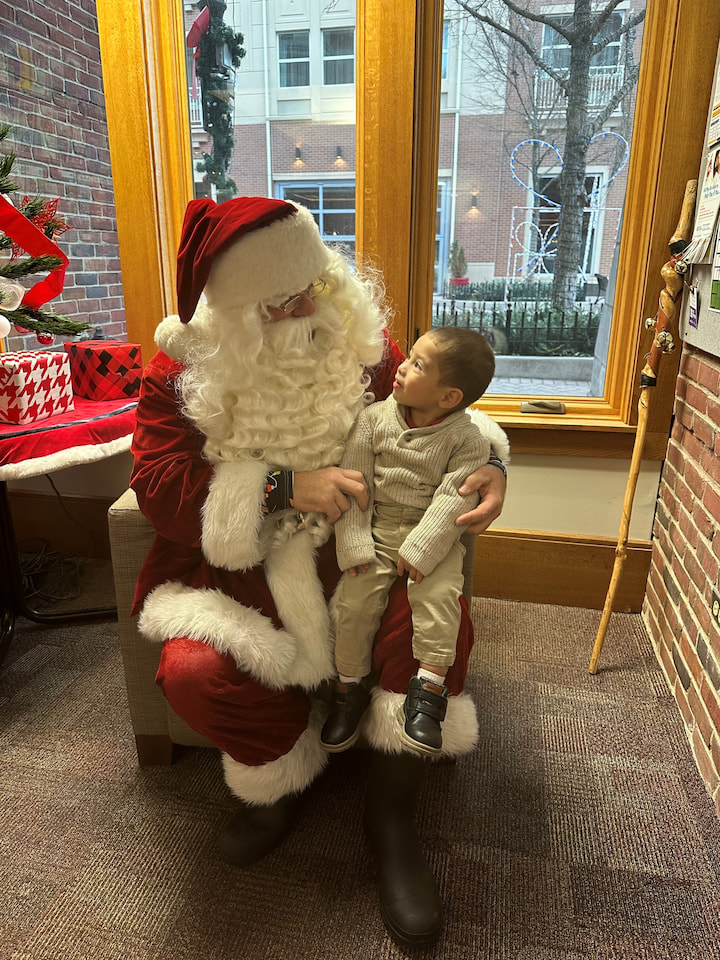 A boy sitting with Santa.