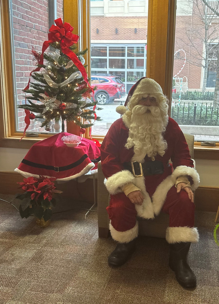 Santa sitting by the CHristmas tree.
