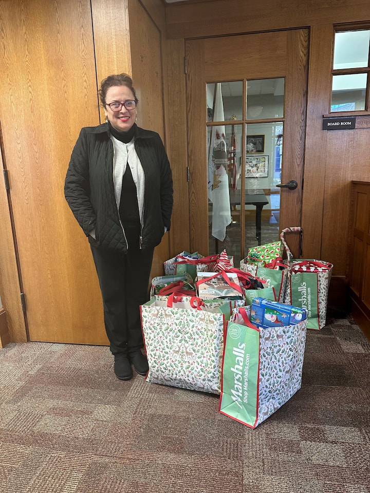 A sponsor from US Bank posing with presents.
