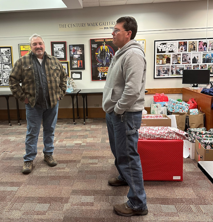 Two volunteers in a candid photo with presents.